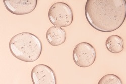 Drops and smears of cosmetics. Drops of liquid transparent gel with bubbles on a brown background