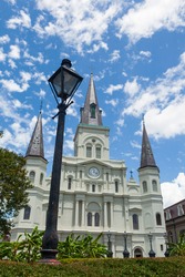St. Louis Cathedral, as seen from Jackson Square in the French Quarter of New Orleans, Louisiana, USA during a summer day with clouds in the sky.