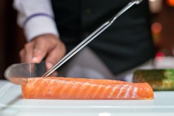 Professional chef cutting smoke salmon prepare for customer appetizer