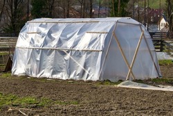 A men made greenhouse for planting vegetable and fruit in winter. Preparing for food shortage by being self sufficient and growing organic food. An off grid farm. A hothouse in the country. Crops.