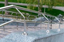 Chrome railing in the park. Stainless steel handrails near the park stairs. Horizontal picture, closeup. high resolution photo