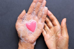 Close up woman washing hands with heart shape soap photo isolate on black top view 