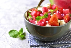 Watermelon salad with feta and mint in a grey bowl.