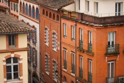 Elevated view over ancient, Southern-style town buildings, constructed in traditional brick on Rue Pharaon Street, in the historic neighborhood of Carmes, in the city center of Toulouse, France