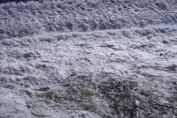 Impressive flow of water on the River Tarn, at the point where the strong current passes the weir of Albi, in France, producing white foam and powerful turbulences