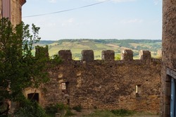 Old stone ramparts dominating a beautiful, verdant landscape in the medieval village of Cordes-sur-Ciel, a fortified town in the agricultural Department of the Tarn, near Albi, in the South of France