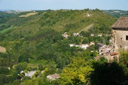 Verdant, hilly countryside landscape with wooded slopes, seen from above, from the ramparts of Cordes-sur-Ciel, a rural medieval town in the region of Albi (Tarn Department), in the South of France