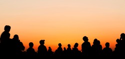 People silhouettes watching sunset sky during airshow