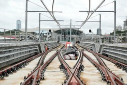 Rails for trains, in the construction of the Metro de Panama. San Miguelito Station in the background
