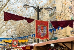 flags hung on a festive day at the medieval market. heraldic shields on some hangings at a street fair. High quality photo horizontal.