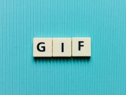 GIF word made from square letter tiles on turquoise background.