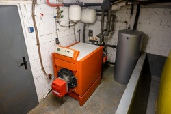 Old oil heating system with oil tank and hot water tank in the basement of a family house - heating with fossil fuels