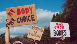 Protesters holding signs My Body My Choice, Bans Off Our Bodies, Abortion Is Healthcare. People with placards supporting abortion rights at protest rally demonstration.