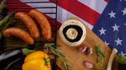Vegetables and sausages prepared for grill. Barbecue party concept for Fourth of July Independence Day holiday celebration in USA, with flag of the United States of America.