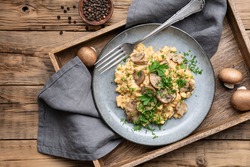 Nutritious scrambled eggs with mushrooms, onion and parsley for breakfast