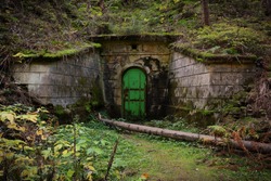 Mine entrance. Unesco heritage Ore mountains mines. Czech Republic, Krusne hory. Underground metal doors in forest. Abandoned mine. Stone building in forest. Mysterious forest place. 