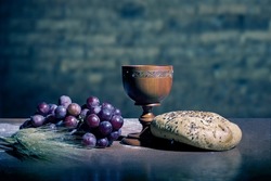 grapes, wheat, bread and wine in a wood table