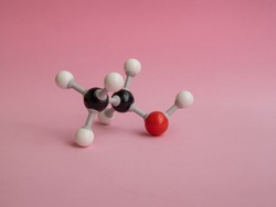 Photo of a molecular atom model isolated on a pink background.
