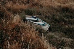 Rustic old boat in grasslands at low tide