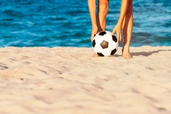 Child soccer player playing with ball on sandy sea beach. Summer sports games, recreation and outdoor activities. Kids have fun on beach. Summer holidays and vacation. Background, banner, copy space