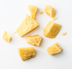Parmesan cheese pieces on white background. Top view.