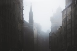 Haunting, spooky and moody atmospheric old town Edinburgh along the medieval Royal Mile in misty fog.
