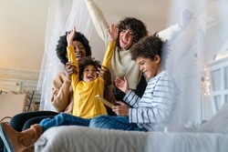 Family children gay parents concept. Happy multiethnic women couple having fun with kids at home