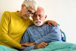 Senior woman with seriously ill husband in hospital. Healthcare support anxiety love concept