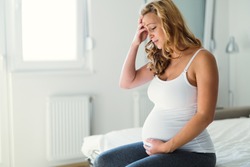 Pregnant woman suffering with headache and nausea