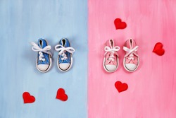 Baby sneakers on pink and blue background, baby shower concept