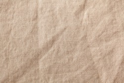 Beige textile linen tablecloth in full frame. Cloth texture background. Copy space.