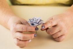 The master sculpts a petal from polymer clay to create a decorative flower.