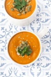Mugs of warm pumpkin soup. The concept of the autumn menu. Autumn recipes.