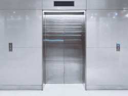 Front view of modern elevator with closed doors in lobby