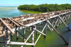 Decommissioned wooden bridge from mainland to Boca Paila Peninsula, spans the outlet of the lagoon to the Caribbean Sea, Puente de Boca Paila, Q.R., Mexico - September 2020: 