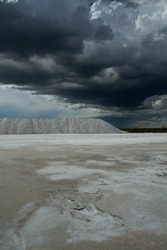 Industrial. View of the natural white salt flats and open cast mining pit under a stormy sky.