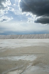 Industrial. View of the natural white salt flats and open cast mining pit under a beautiful sky.