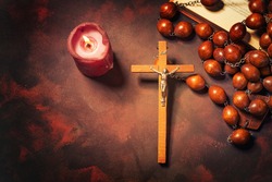 Big wooden Rosary beads and crucifix cross with jesus,red candle and bible book,spiritual atmosphere ,religion concept.