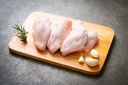 fresh raw middle chicken wings on wooden board with ingredients