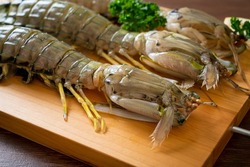 fresh mantis shrimp with lemon on wood board