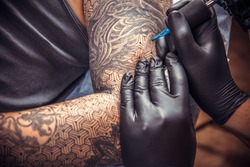 Tattooist posing in tatoo salon.