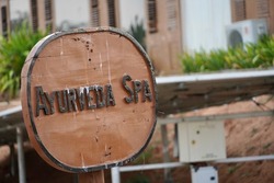 Ayurveda spa signboard kept in front of the Indian traditional massage center. Directional sign board pointing the SPA location at the resort.