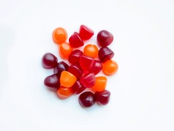 Group of red, orange and purple multivitamin gummies isolated on white background. Healthy lifestyle concept.