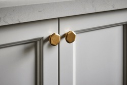 Photography detail of shaker style kitchen cupboard joinery doors and brushed gold handles.