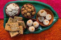 Makar sankranti special cuisine dish items Rewri, Tilgul, Til ke laddu, Chikki, Til baati all sweet items made with white sesame seeds and jaggery. Winter special indian food healthy seasonal