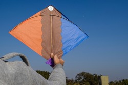 Boy flying Kite on Indian Kite flying festival of Makarsankranti, Lohri, Pongal or Uttarayan with clear sky background. Blank space to write text or font wishes.Uttarayan celebrations on house terrace