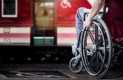 Cropped image of man in his wheelchair at railway station platform waiting for train