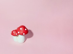 Polka dot patterned mushrooms, isolated pair against pastel pink background. Creative natural layout. Summer outdoor activities.