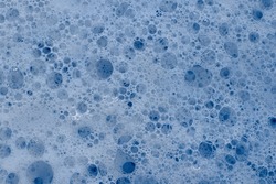 Close-up of blue-tinted soapy foam. Background for design