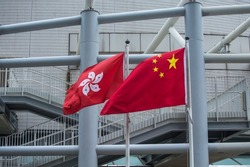Chinese flag and Hong Kong flag over building background.